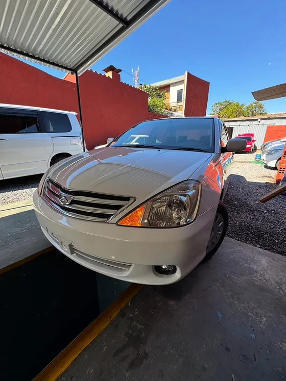 Toyota Allion blanco con luces encendidas